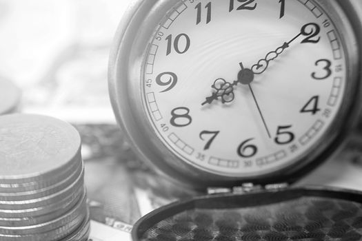 classic pocket watch and coins on dollar banknote, concept and idea of time value and money, business and finance concepts.