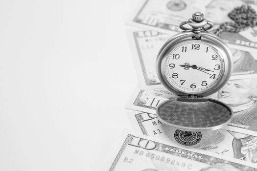 Classic pocket watch on dollar banknote, concept and idea of time value and money, business and finance concepts.