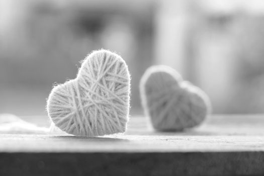 soft color knitting wool in shape of heart on vintage wooden with bokeh soft light background