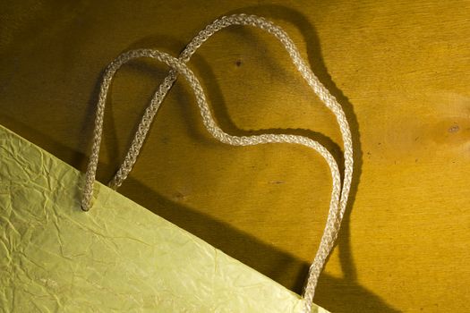 Rope handles from a paper bag on a wooden background