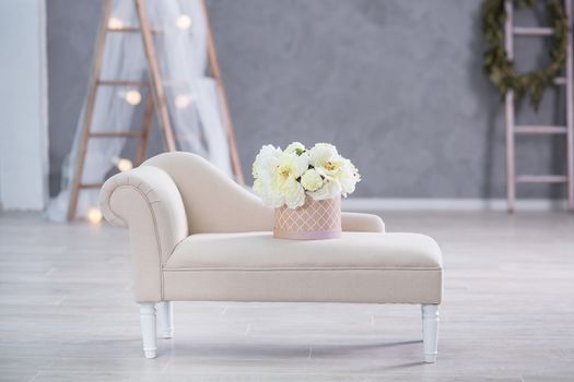 Interior mock up photo. Blue wall with leather material divan sofa and pot with plant flowers and ladder. Background photo with copy space for text