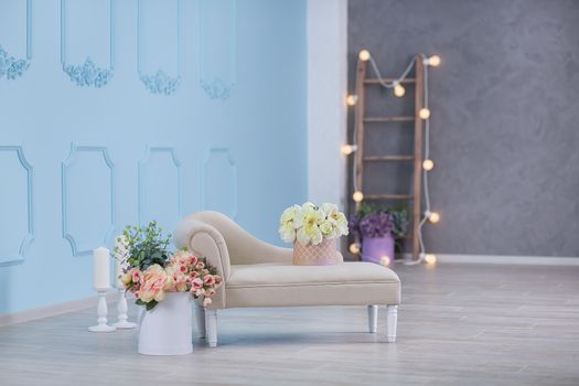 Interior mock up photo. Blue wall with leather material divan sofa and pot with plant flowers and ladder. Background photo with copy space for text