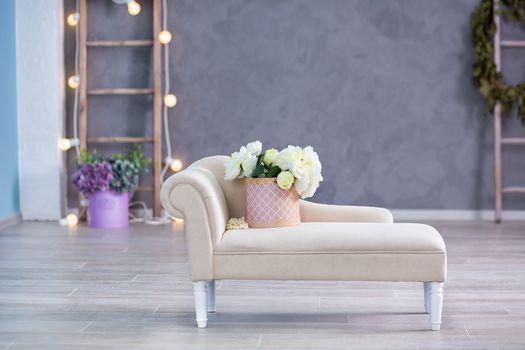 Interior mock up photo. Blue wall with leather material divan sofa and pot with plant flowers and ladder. Background photo with copy space for text