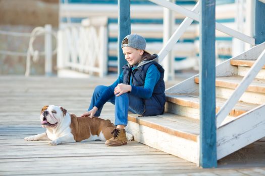 Nice looking handsome boy on beach with english bulldog