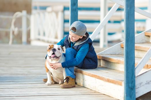 Nice looking handsome boy on beach with english bulldog