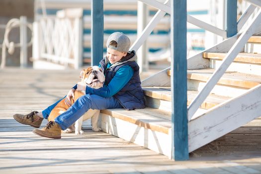 Nice looking handsome boy on beach with english bulldog