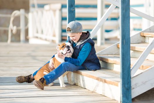 Nice looking handsome boy on beach with english bulldog