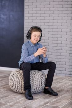 Relax and listening music concept. European boy fill the bit. Portrait of head in headphones with closed eyes. Boy in casual wear.