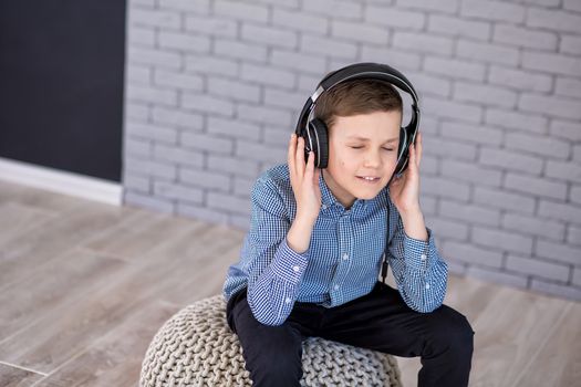 Relax and listening music concept. European boy fill the bit. Portrait of head in headphones with closed eyes. Boy in casual wear.