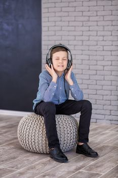 Relax and listening music concept. European boy fill the bit. Portrait of head in headphones with closed eyes. Boy in casual wear.