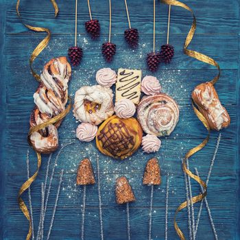 Different cookies on blue wooden background for happy new year holiday, top view
