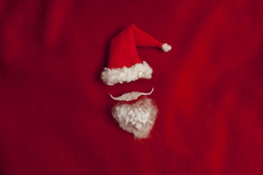 Red Santa Claus hat on red background minimalism, conceptual image. Holiday, Christmas New Year flat lay
