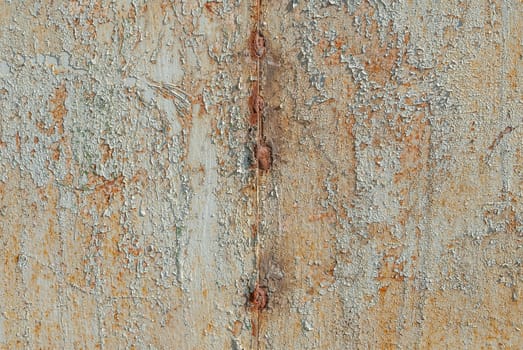 fragment of a rusty iron surface covered with old paint, which has long been under the influence of different climatic conditions