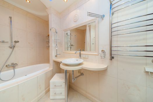 Small beige tile bathroom with bath tube and sink