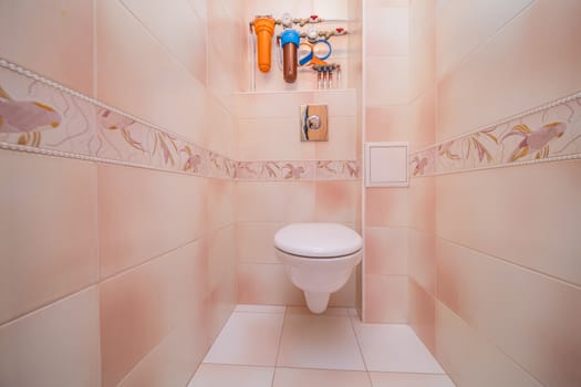 Toilet bowl in the toilet room. Restroom with brown tile decoration