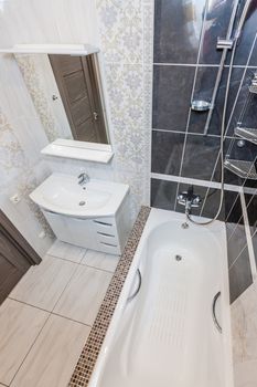 Small beige tile bathroom with bath tube and sink