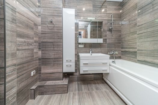 Small beige tile bathroom with bath tube and sink