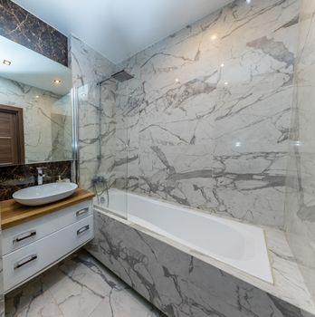 Small beige tile bathroom with bath tube and sink