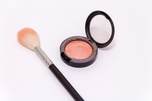 Close up of makeup brush and blush box isolated on white background.