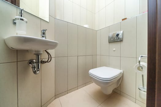 Toilet bowl in the toilet room. Restroom with brown tile decoration