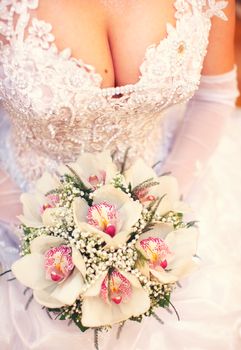 Bride holding lily orchid bouquet in hands 