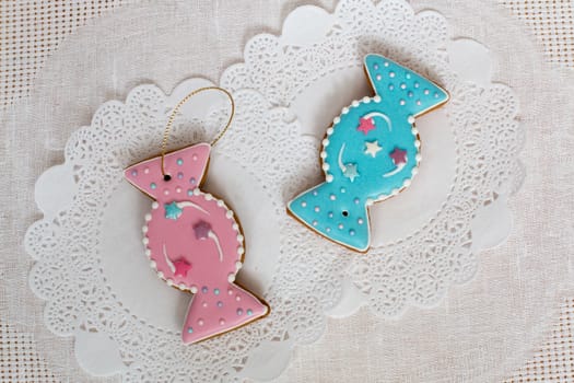 Two gingerbread cookies in the shape of candy on a white napkin background. Top view, flat lay, copy space. Curly Christmas gingerbread home cooking