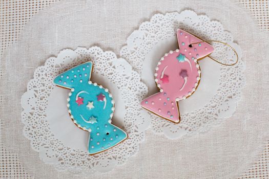 Two gingerbread cookies in the shape of candy on a white napkin background. Top view, flat lay, copy space. Curly Christmas gingerbread home cooking