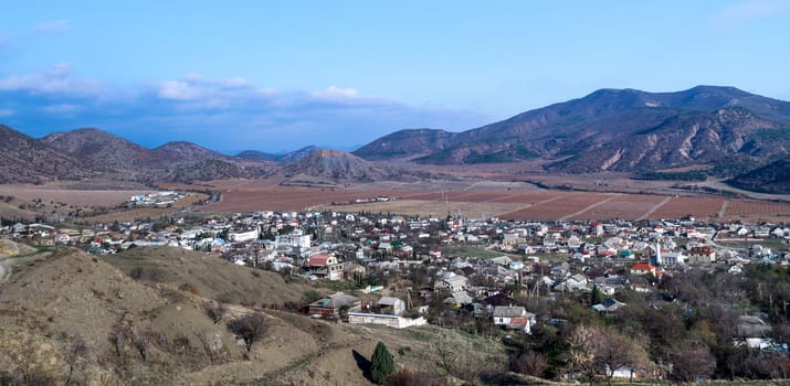 Crimean village nestled in the foothills, among autumnal vineyard