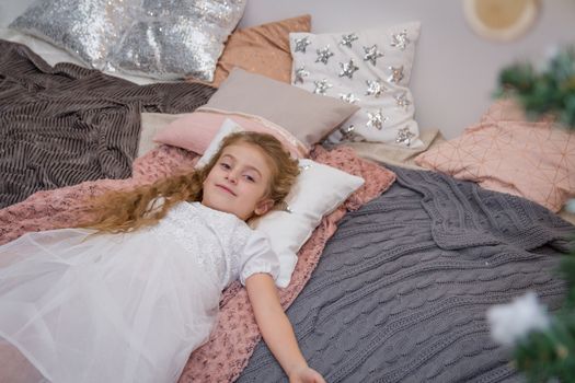 Sweet girl lying on pillow in winter studio