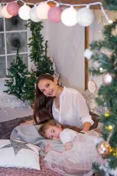 Mother and daughter lying cosy in winter studio