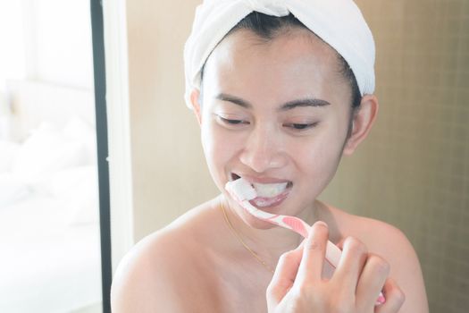 Closeup woman brushing teeth in bathroom, health care and beauty concept, selective focus