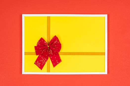 Christmas decorative red bow in a white frame on a colored background