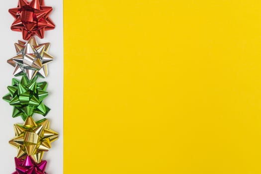 Christmas decorative colored bows  on a yellow background