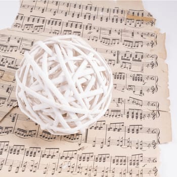 A ball made with white wooden slats over a musical score
