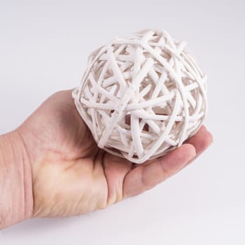 A ball made with white wooden slats on the hand