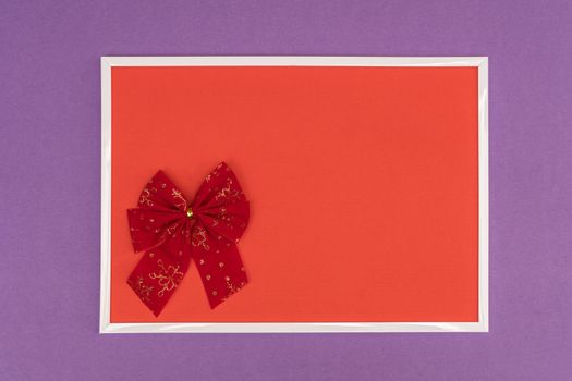 Christmas decorative bow in a white frame on a colored background