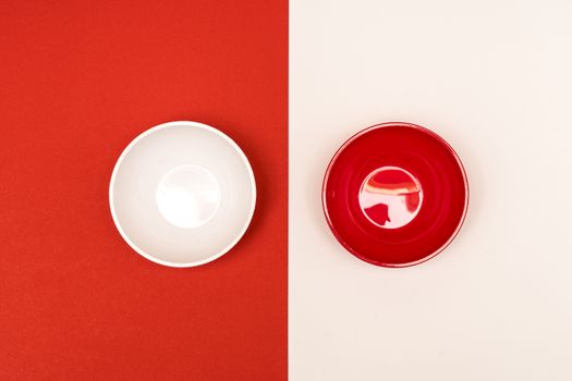 red and white bowls arranged opposite each other on a colored background