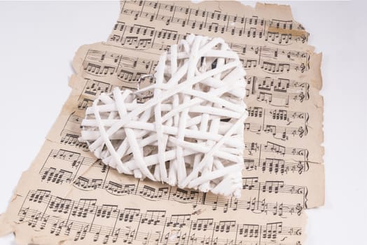 heart made with white wooden slats over a musical score