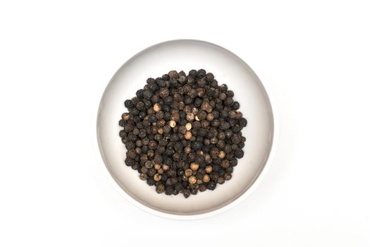 black pepper in a bowl on a colored background