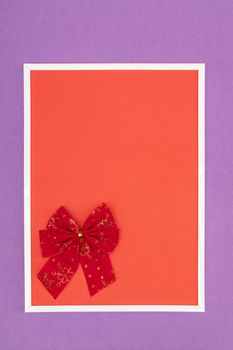 Christmas decorative red bow in a white frame on a colored background