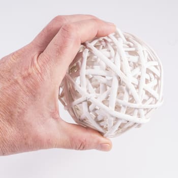 a ball made with white wooden slats on the hand