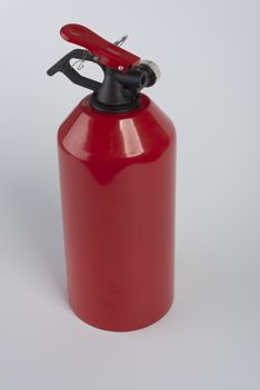 red fire extinguisher on the white table