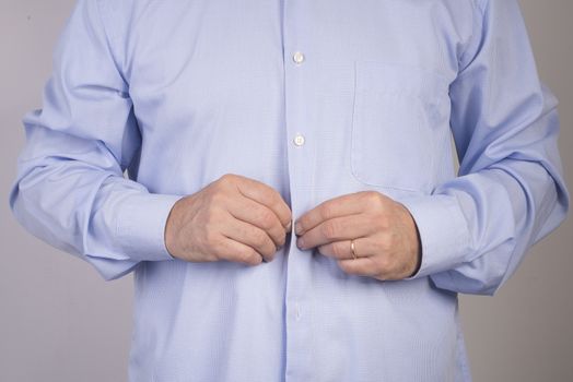 a man buttoning his shirt