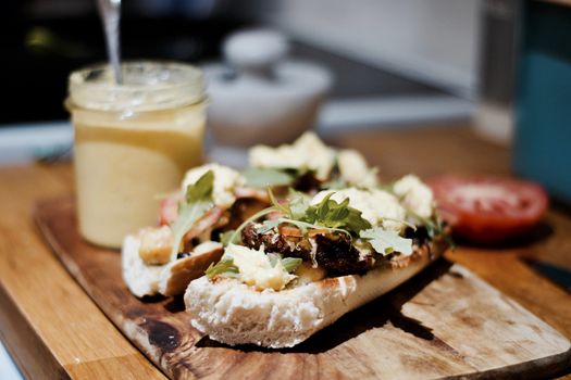 Delicious sandwich on the wooden board in the kitchen.