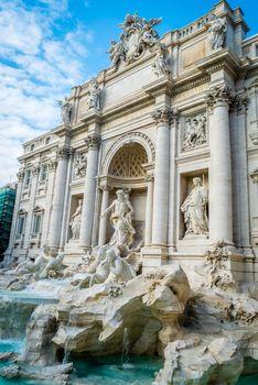 Trevi fountain in Rome in daylight with blue sky and clouds