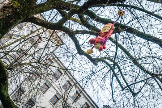 Cuddly toy lost in a tree as an allegory of a lost broken childhood