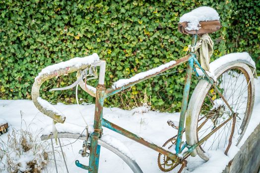 Old bike covered with snow in the winter