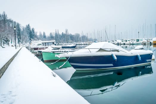 Boats in harbour under the snow in the winter