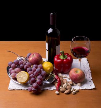 fruits, vegetables and a bottle of red wine on the table