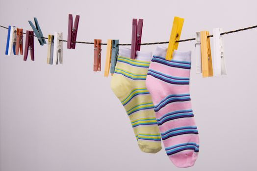 two socks hanging on a thread to dry